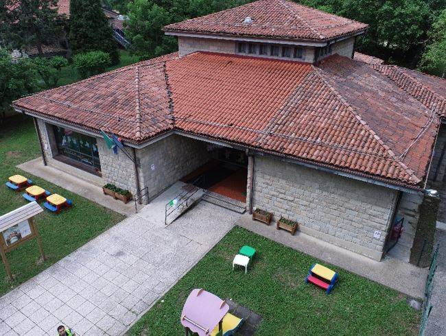 Vista aerea della scuola in pietra oggetto di miglioramento sismico a Monteombraro (Modena), con copertura in coppi e facciate in muratura portante.