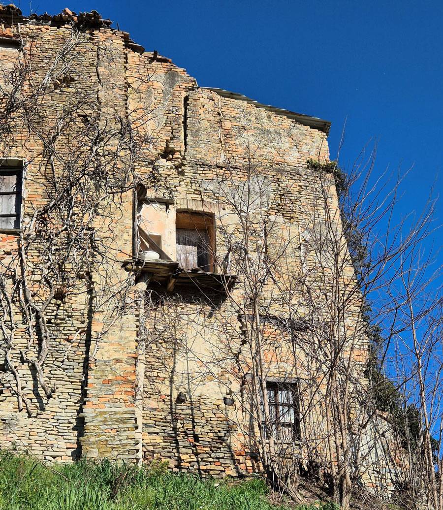 Separazione muraria per scarsa qualità della tessitura e mancanza di efficaci collegamenti tra la parte originaria e la superfettazione di un edificio in stato di abbandono soggetto a cedimento fondale
