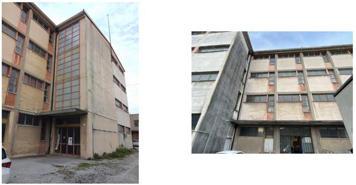 “Fotografie dell’edificio esistente, una struttura scolastica di più piani con facciata deteriorata in cemento e finestre rettangolari, che mostra segni di usura e necessità di riqualificazione.”