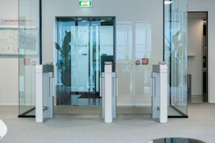 Tornelli con barriere in vetro per il controllo accessi in edificio direzionale