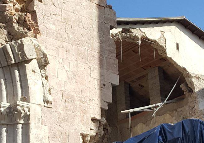 Danni strutturali alla Basilica di San Benedetto a Norcia dopo il sisma: crollo della muratura e residui di barre di ancoraggio del cordolo in cemento armato.