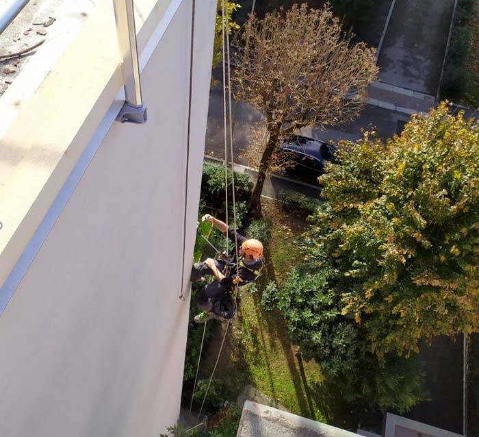 Particolare dell’operatore in fune durante le lavorazioni all’esterno di un edificio 