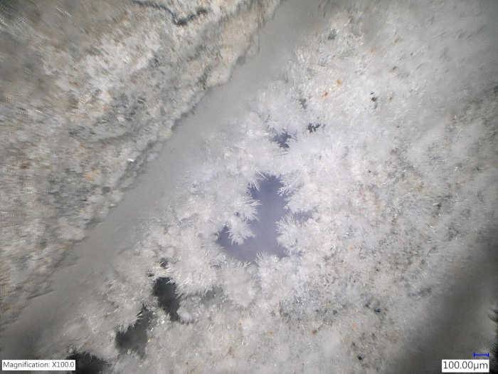 La crescita cristallina in una fessura di calcestruzzo al microscopio