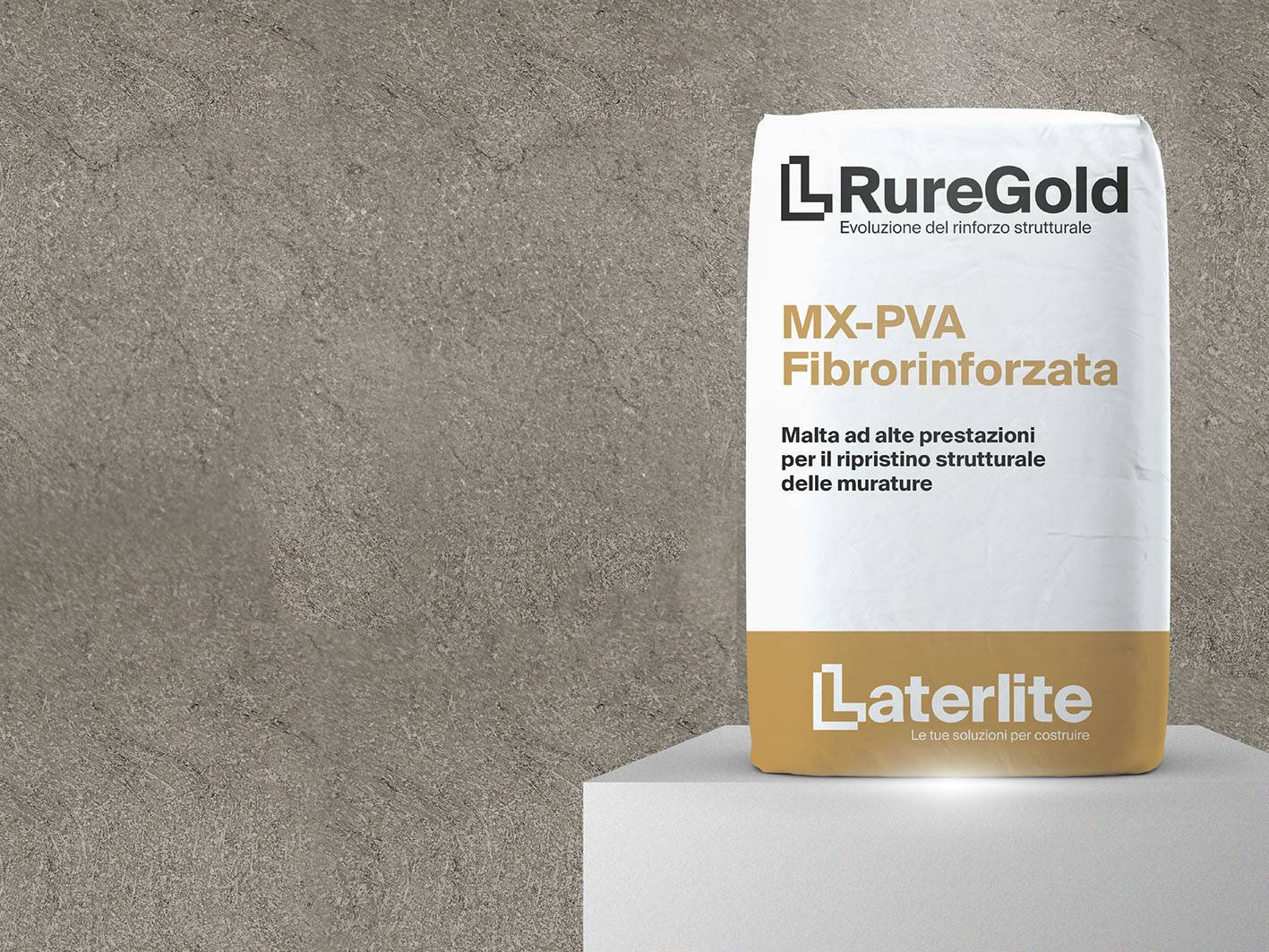Sacco di malta strutturale RureGold MX-PVA Fibrorinforzata prodotto da Laterlite, appoggiato su un piedistallo davanti a una parete in cemento. Sulla confezione bianca con fascia dorata inferiore sono riportate le scritte: ‘RureGold – Evoluzione del rinforzo strutturale’, ‘MX-PVA Fibrorinforzata’, e ‘Malta ad alte prestazioni per il ripristino strutturale delle murature’. In basso compare il logo Laterlite con il motto ‘Le tue soluzioni per costruire