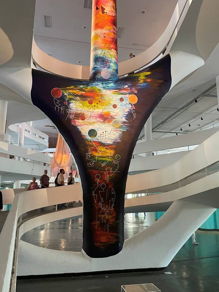 Gigantesca freccia indígena, che sfonda il soffitto del padiglione della 36esima Biennale d’arte di San Paolo dedicata a “Nem Todo Viandante Anda Estradas Da Humanidade como Prática” nel Parco Ibirapuera di San Paolo. È un’opera dell’artista visuale e filosofo Tanka Fonta.