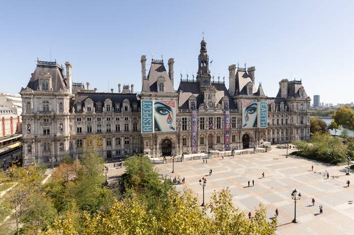 Parigi. Un bosco davanti all’Hotel de Ville e un'opera d'arte sulla sua facciata con la scritta 