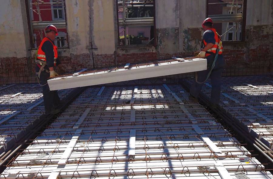 Installazione manuale degli elementi Airfloor su struttura esistente, posa del solaio misto autoportante in intervento di ristrutturazione scolastica.